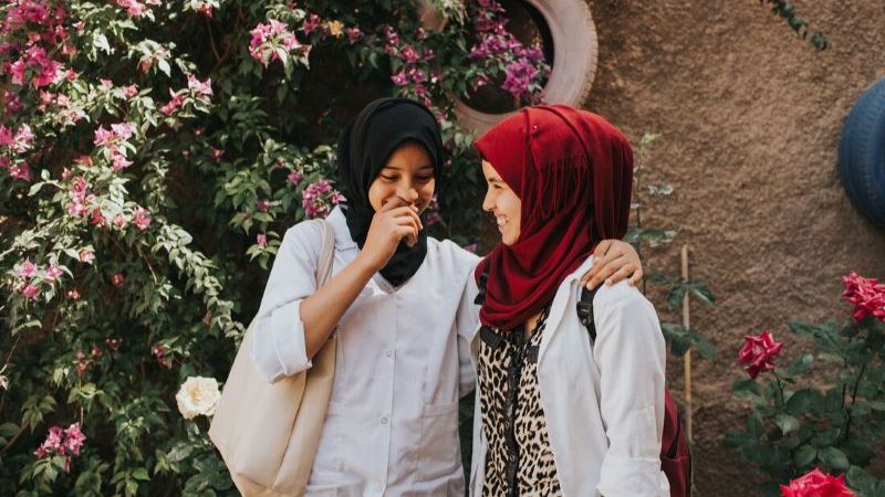 Two girls laughing together at school