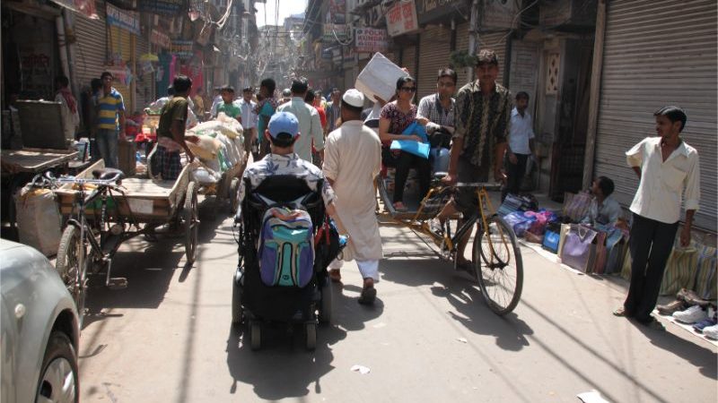 A man in a wheelchair navigating traffic in India