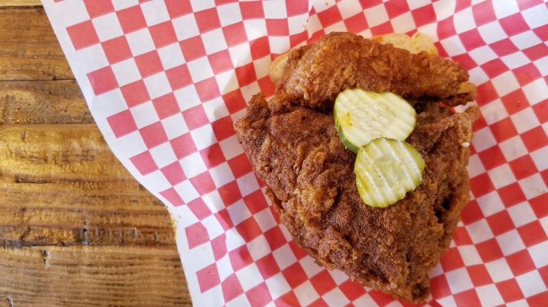 Deep-fried chicken on a red and white checked piece of paper.