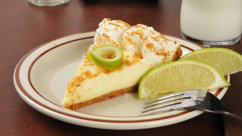 Slice of pie with two wedges of lime on a plate