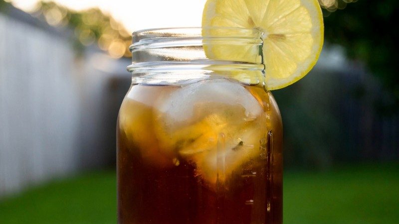 Jar of tea, ice cubes and a slice of lemon.