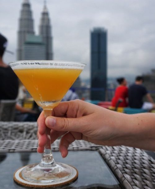 Cocktail on a rooftop with tall building in the background