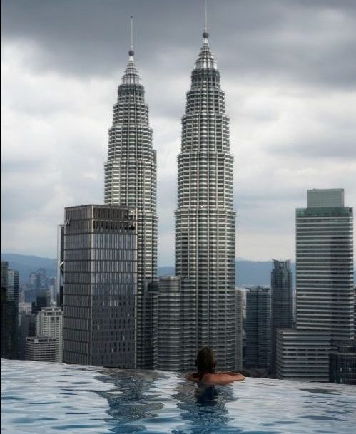 Person swimming in an infinity pool on a rooftop