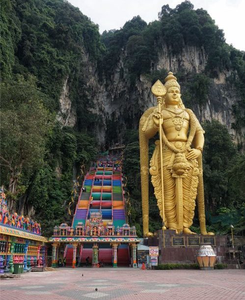 Enormous gold statues of Buddha in the side of a mountain