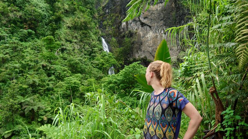 A girl standing in front of a waterfall in Fiji