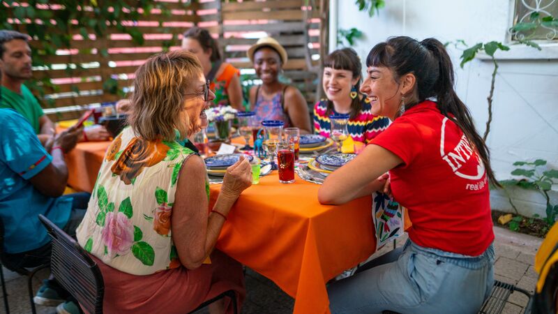 A group of travellers sit around a table in Mexico