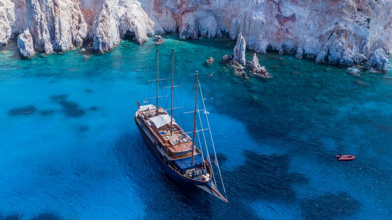 aerial shot of a small ship moored in a Greek bay.