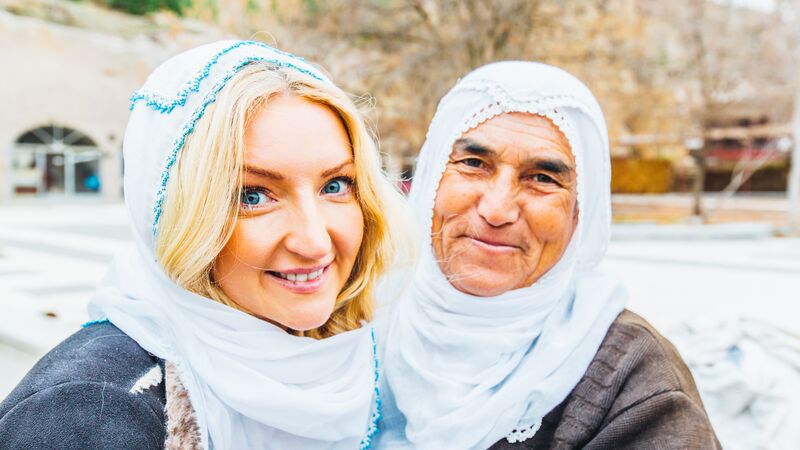 A traveller smiles with a local woman in Turkey