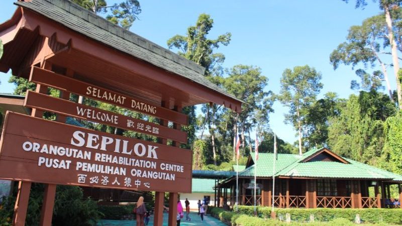 A sign for Sepilok with a house in the background