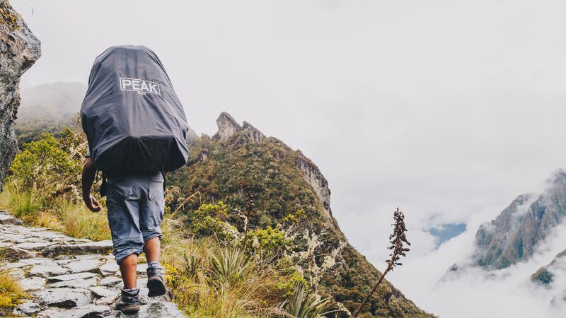 A porter with a big bag on his back on the Inca Trail