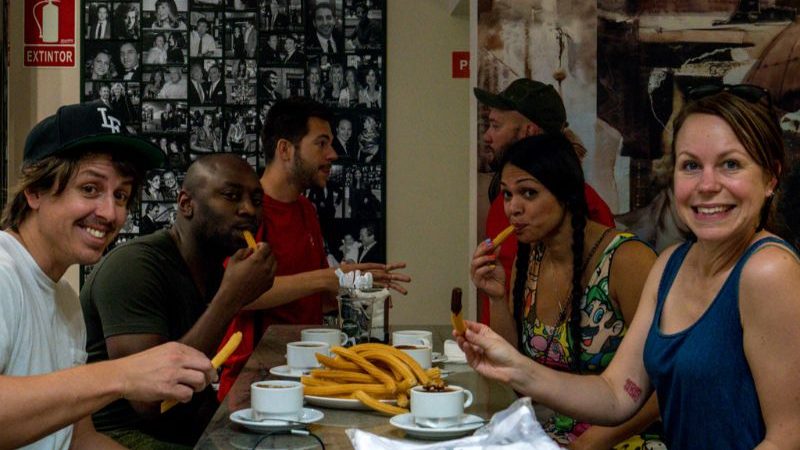 A group of people smiling and eating churros