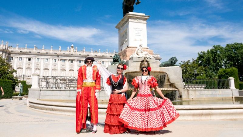 Three people wearing dressups outside a palace