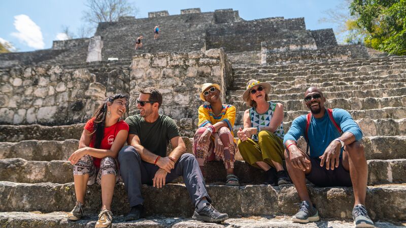 A group of travellers sitting at a ruin in Mexico