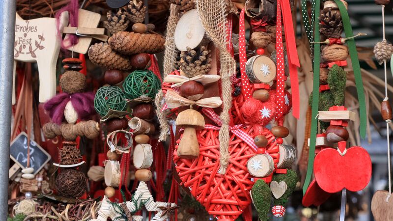 Wooden Christmas decorations hanging at a market stall.