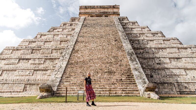 A female traveller standing in front of some ruins in Mexico