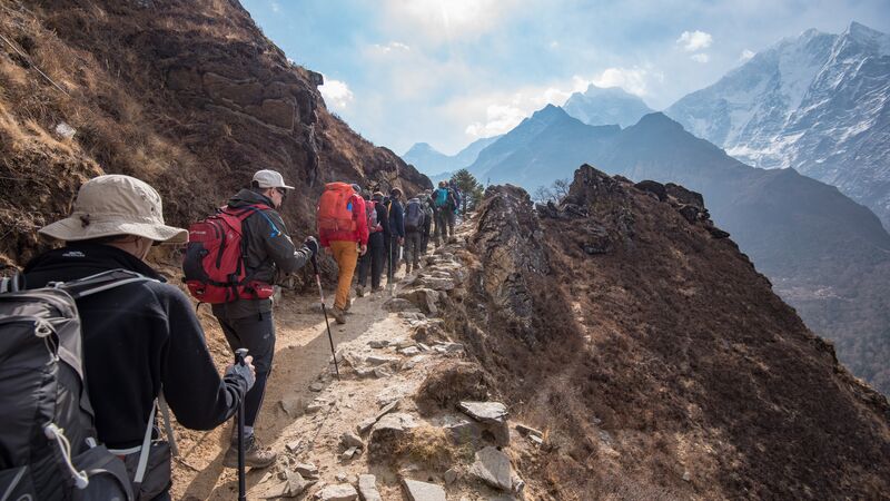 Hikers walking up a rocky path in Nepal