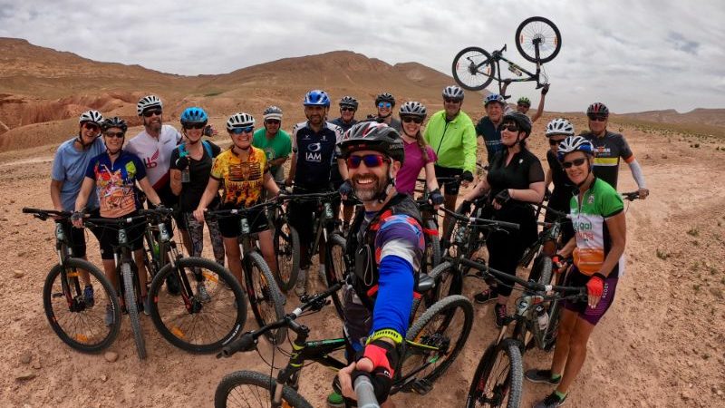 A group of cyclists taking a selfie in the Moroccan desert