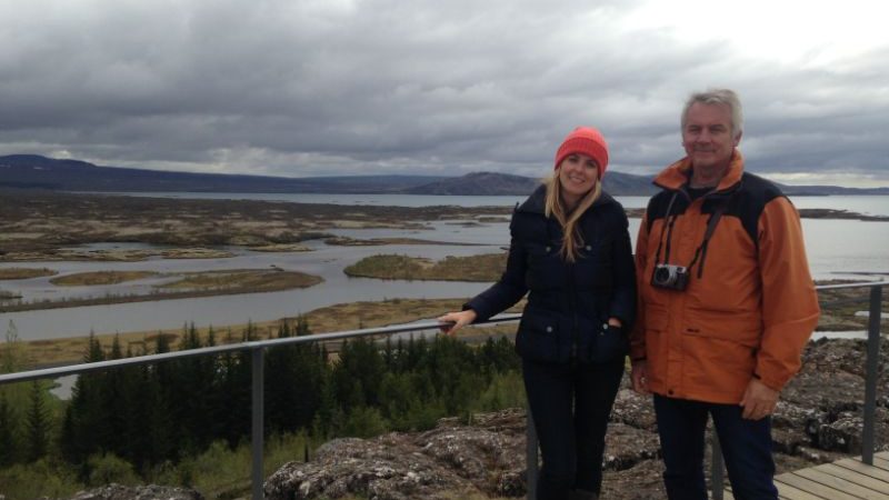 A father and daughter standing on a boardwalk in Iceland