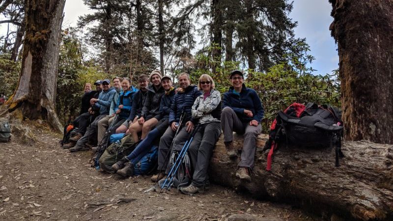 A group of trekkers sitting on a log in Nepal