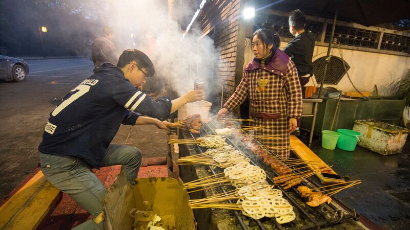 Two people working on a food stall on the street in China