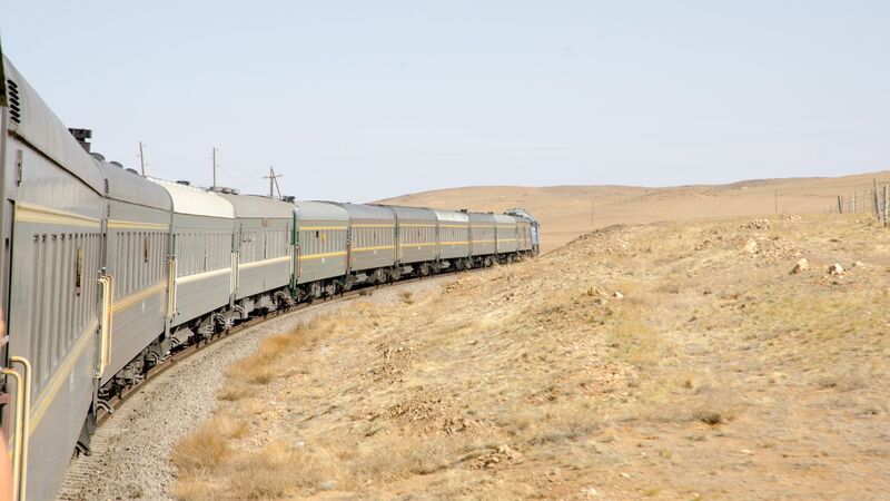 A train curls across the barren landscape in China