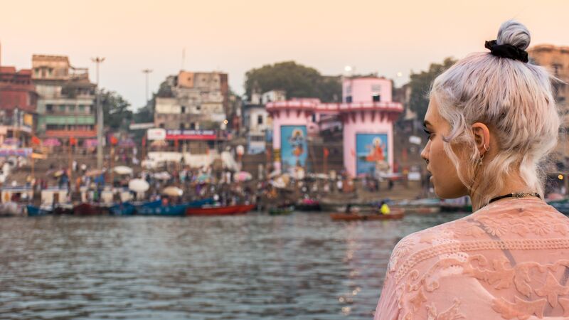 A young woman looks out over the river in Varanasi