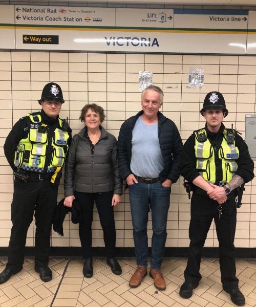 Two people standing between two policemen in London