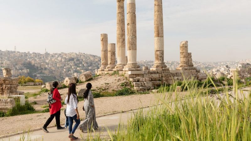 Travellers walking past some ruins in Jordan