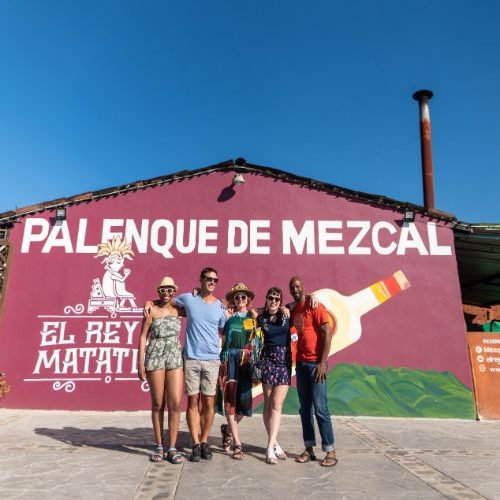 Five people standing in front of a mezcal distillery