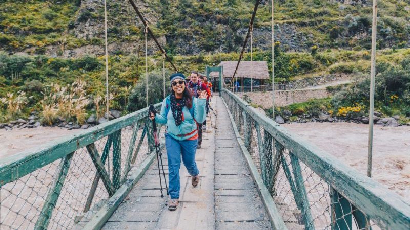 Hikers crossing a bridge in Peru