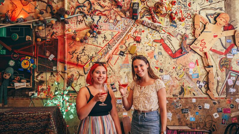 Two women with drinks at a bar in Budapest