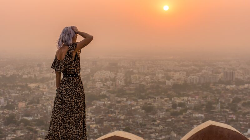 A woman looking at a view in India at sunset