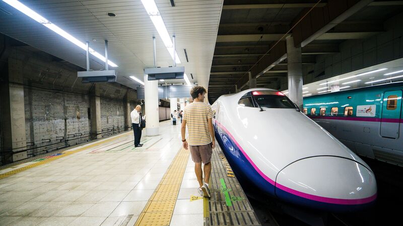 A young man getting onto a bullet train in Japan