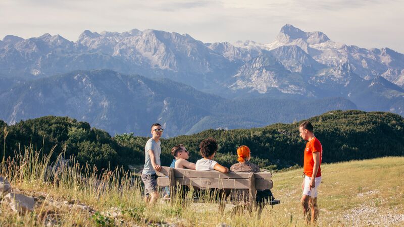 A group of travellers sitting in a field in Slovenia