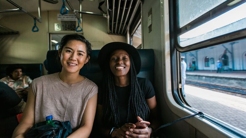 Two smiling women on a train in Sri Lanka