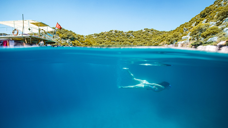 An underwater photo of a woman swimming in blue water