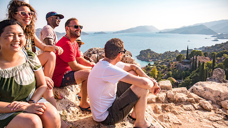 A group of travellers sitting on a rock in the sun in Turkey