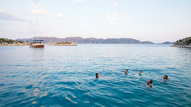 A group of travellers swimming in blue seas in Turkey