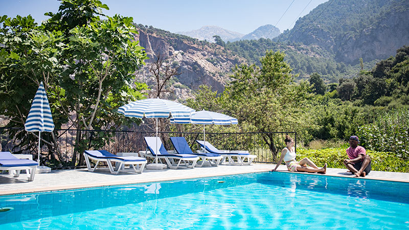 Two people relaxing by a pool in Turkey