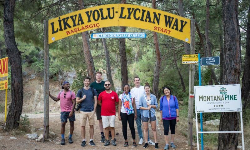 A group of travellers standing under a sign on the Lycian Way in Turkey
