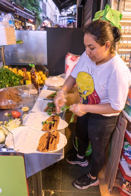 A woman prepares a traditional Turkish street food at a market