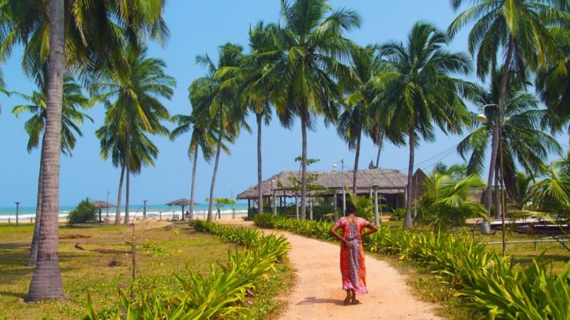 a woman in a sari walking towards a beach.