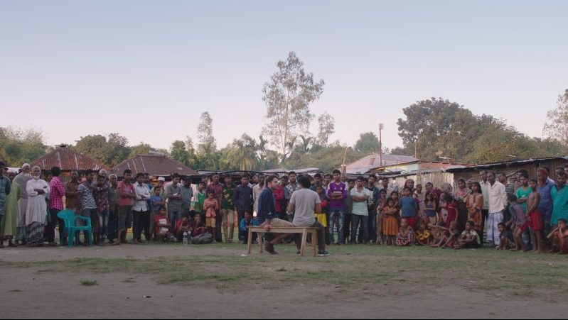 Two men have a meeting in the middle of a village