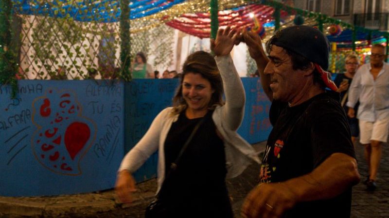 A man and woman dance in the street.