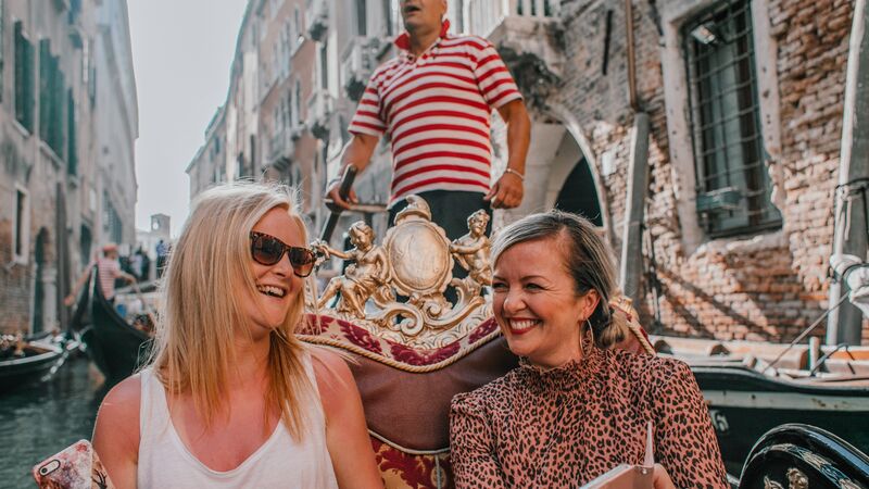 Two travellers enjoying a gondola ride in Venice