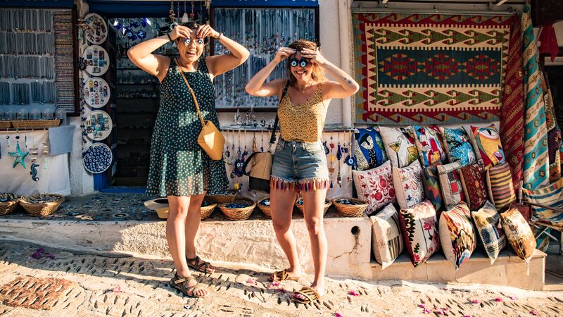 Two women in Turkey holding evil eyes over their eyes