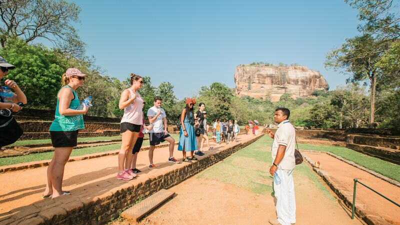A group of travellers and their tour guide at Sigiriya, Sri Lanka