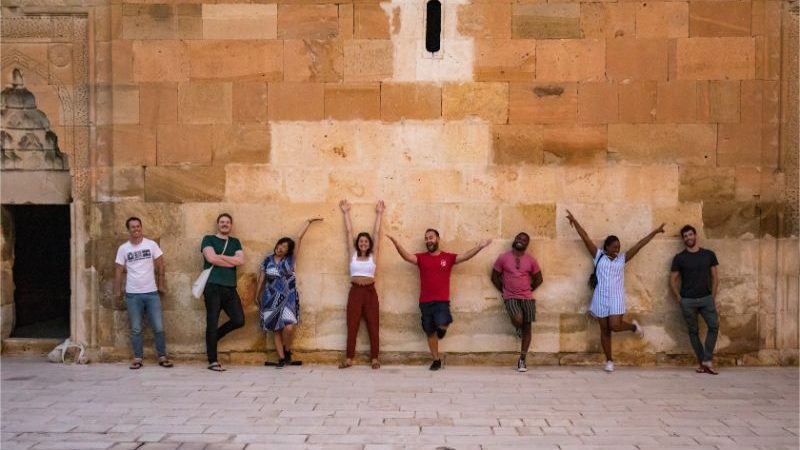 A group travellers posing in front of a wall in Cappadocia