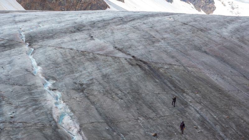 Two hikers climbing a glacier