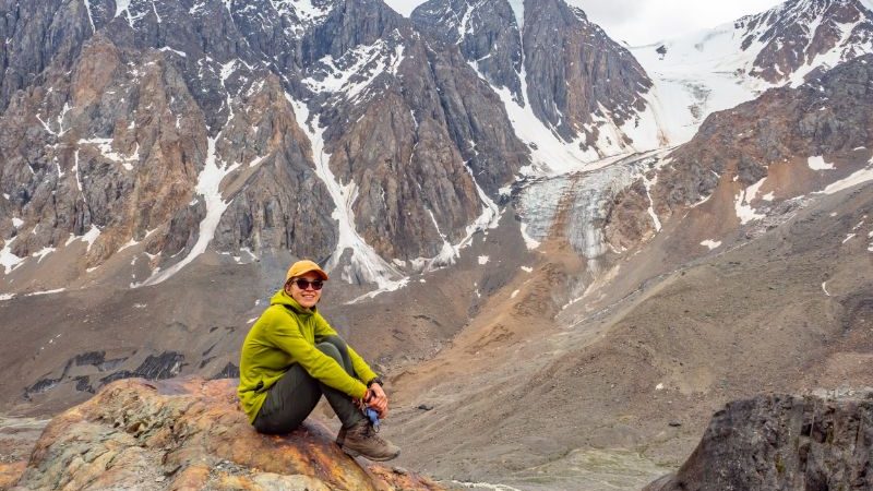 A traveller sitting on a rock in the Aktru Mountains